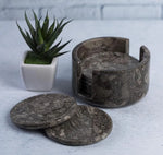 Round oceanic marble coaster set with holder beside a small potted succulent