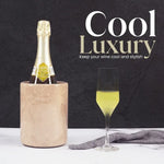 Round verona marble wine chiller keeping a champagne bottle cool beside a filled flute