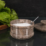 Marble salt jar placed on wooden kitchen shelf	