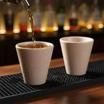 Drink poured into a verona marble shot glass on a bar mat