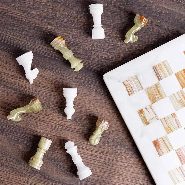 White and green onyx marble chess set 12 inch — pieces scattered on dark wood surface showing white marble and green onyx stone detail by RADICALn