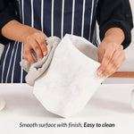 Hands wiping a white marble utensil crock, showing its smooth easy-to-clean surface