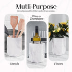 White marble wine cooler holding utensils, a wine bottle and flowers