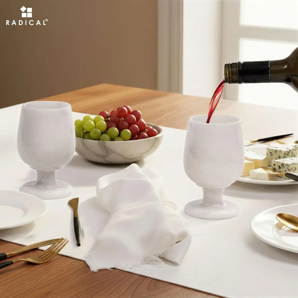 White red wine poured into a green onyx marble wine glass at a set dinner table