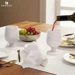 White red wine poured into a green onyx marble wine glass at a set dinner table