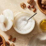 Overhead view of a white onyx marble salt cellar filled with coarse salt, spoon inside and lid resting beside it